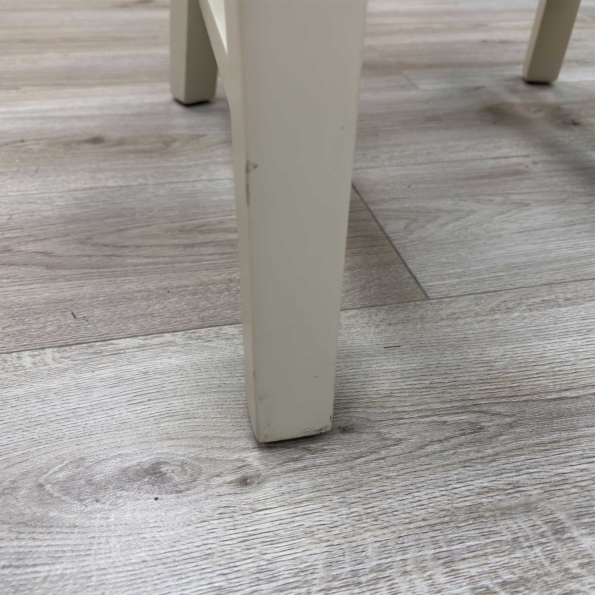 Close-up view from a high angle looking down at the seat and backrest junction, displaying the flawless edge finishing, tight tolerances, and pristine tailored construction lines.Damage on chair Legs.