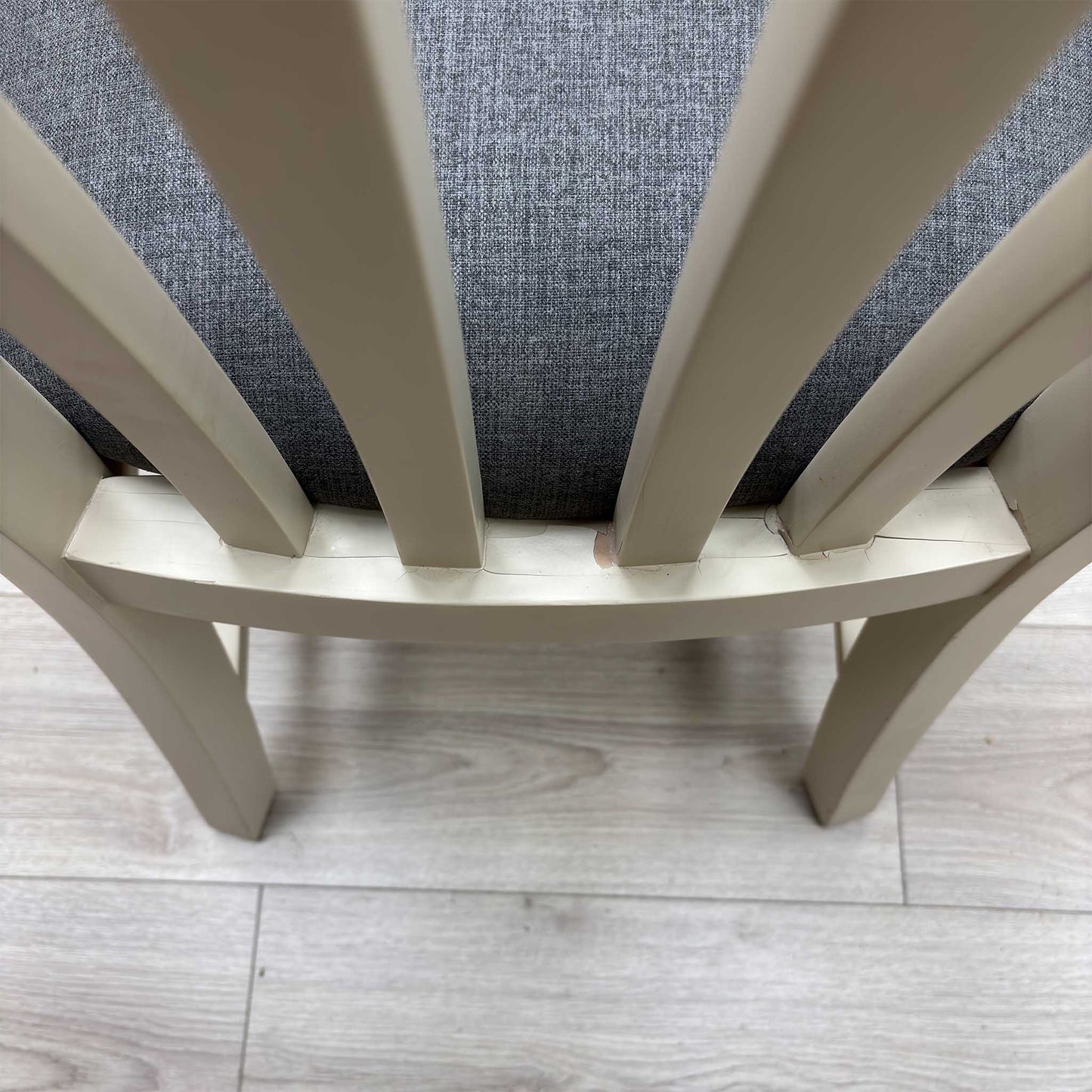 Close-up view from a high angle looking down at the seat and backrest junction, displaying the flawless edge finishing, tight tolerances, and pristine tailored construction lines.Damage on chair.
