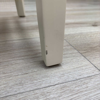 Close-up view from a high angle looking down at the seat and backrest junction, displaying the flawless edge finishing, tight tolerances, and pristine tailored construction lines.Damage on chair leg.