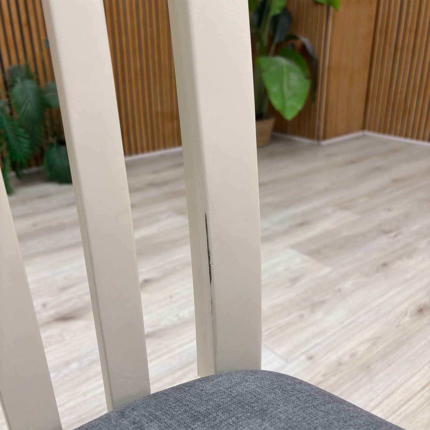 Close-up view from a high angle looking down at the seat and backrest junction, displaying the flawless edge finishing, tight tolerances, and pristine tailored construction lines.Damage on chair.