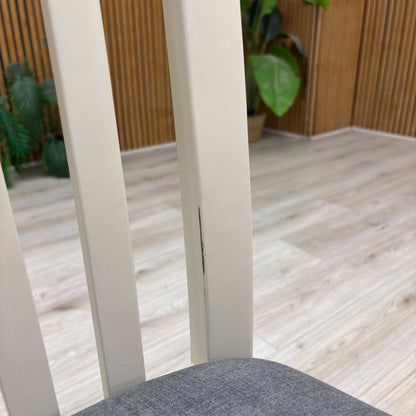 Close-up view from a high angle looking down at the seat and backrest junction, displaying the flawless edge finishing, tight tolerances, and pristine tailored construction lines.Damage on chair.