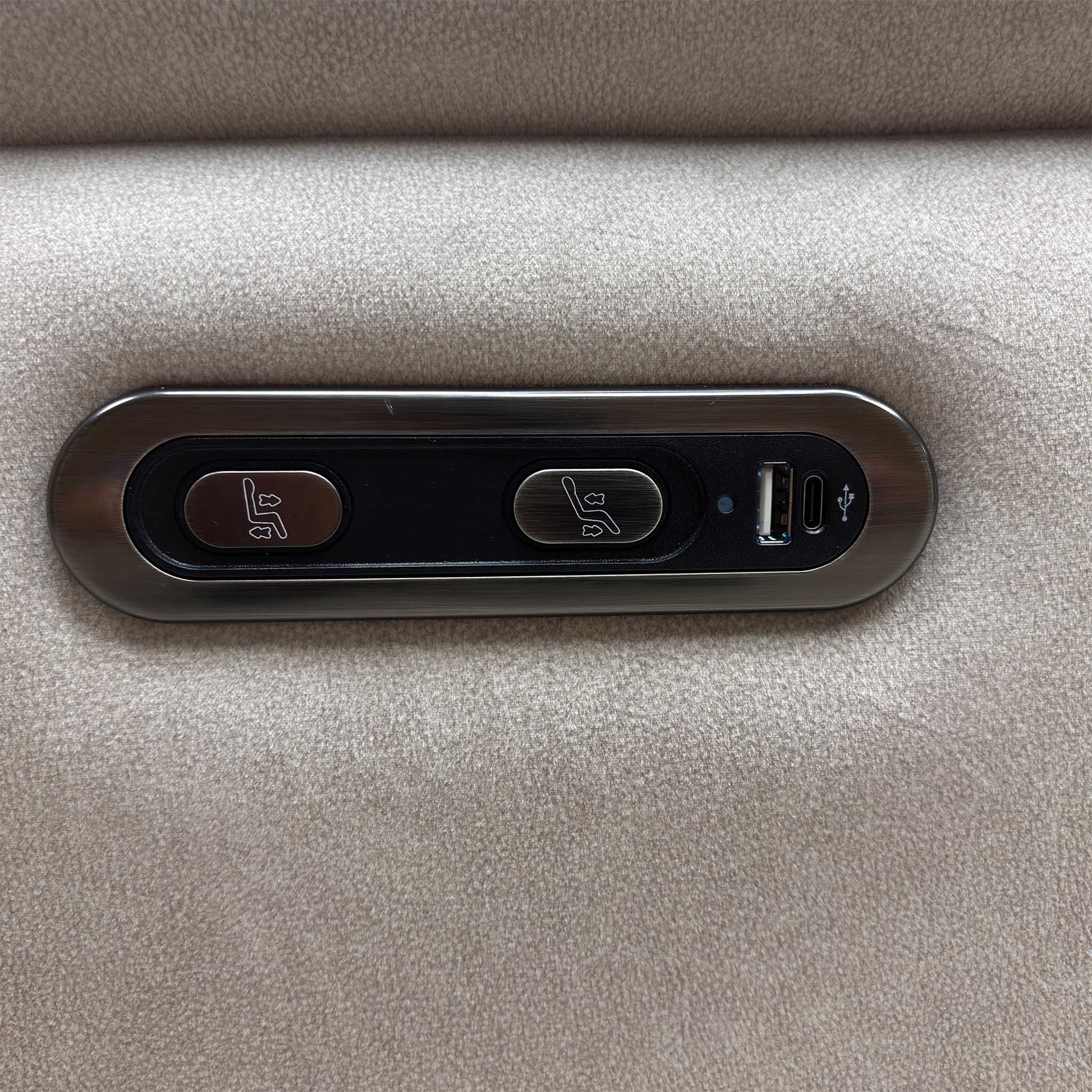 Close-up view of the outer armrest detailing the integrated power adjustment buttons for seamless reclining operation along with a convenient built-in USB charging port.