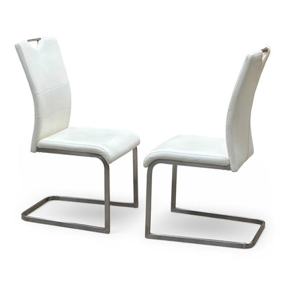 Side perspective profile view of a chair, demonstrating the classic gravity-defying cantilever suspension curve, supportive backrest angle, and sleek polished chrome metal finish.