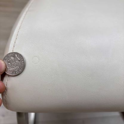 High-definition close-up macro view of the Bianco White faux leather upholstery, detailing the premium fine-grain surface texture, pristine matte finish, and clean modern tailoring lines.Small defect on the chair.