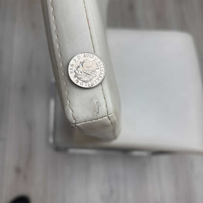High-definition close-up macro view of the Bianco White faux leather upholstery, detailing the premium fine-grain surface texture, pristine matte finish, and clean modern tailoring lines.Small defect on the chair.