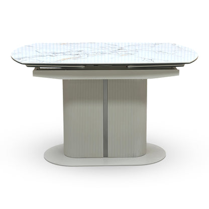 Avorio ivory ceramic dining table shown fully extended. Displays the unique rotating swivel top action that smoothly pivots to reveal integrated extensions, expanding the surface area for additional dining seating.