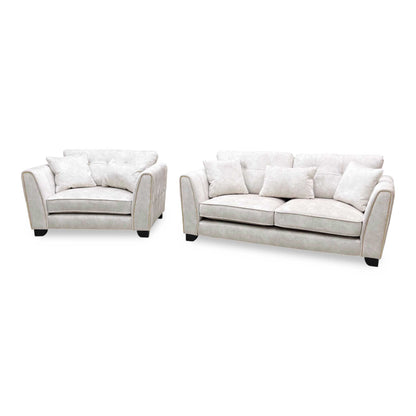 Mariah Dapple ivory fabric 3 seater sofa and snuggler chair angled from the left, showing the piped flared arms