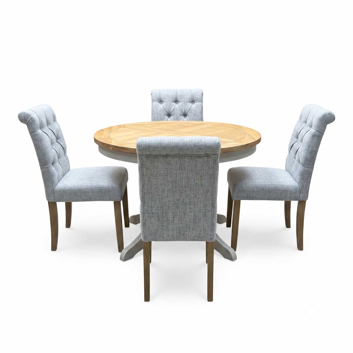 ‘Lewis’ Natural Oak Round Pedestal Butterfly Extending Dining Table with Mist Grey Fabric Button Back Dining Chairs - Set of 4 Furniture Village