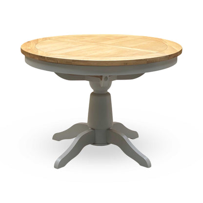 ‘Lewis’ Natural Oak Round Pedestal Butterfly Extending Dining Table with Mist Grey Fabric Button Back Dining Chairs - Set of 4 Furniture Village