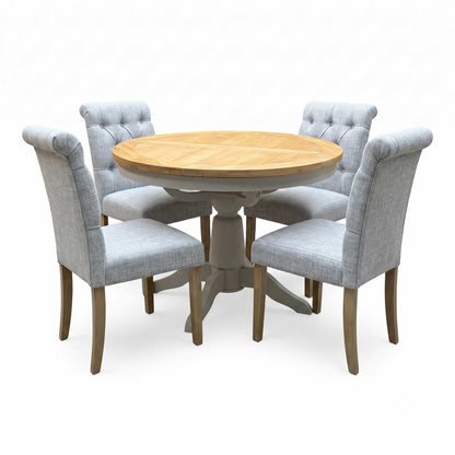 ‘Lewis’ Natural Oak Round Pedestal Butterfly Extending Dining Table with Mist Grey Fabric Button Back Dining Chairs - Set of 4 Furniture Village