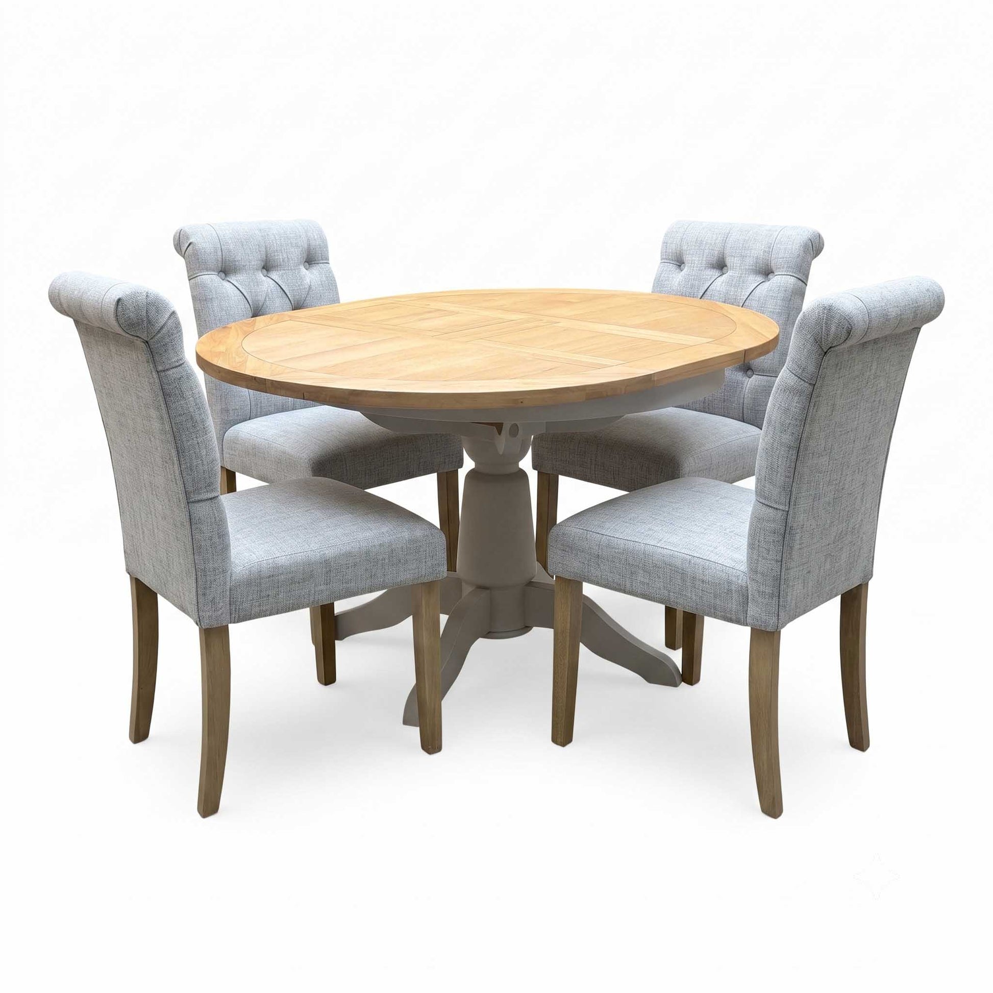 ‘Lewis’ Natural Oak Round Pedestal Butterfly Extending Dining Table with Mist Grey Fabric Button Back Dining Chairs - Set of 4 Furniture Village