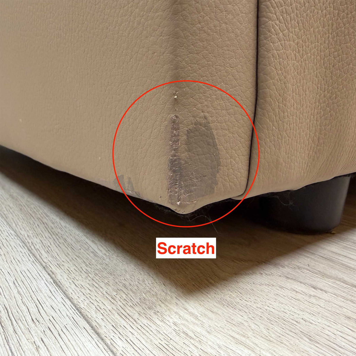 Close-up of a scratch on the bottom corner of the G Plan Avon taupe leather sofa near the foot