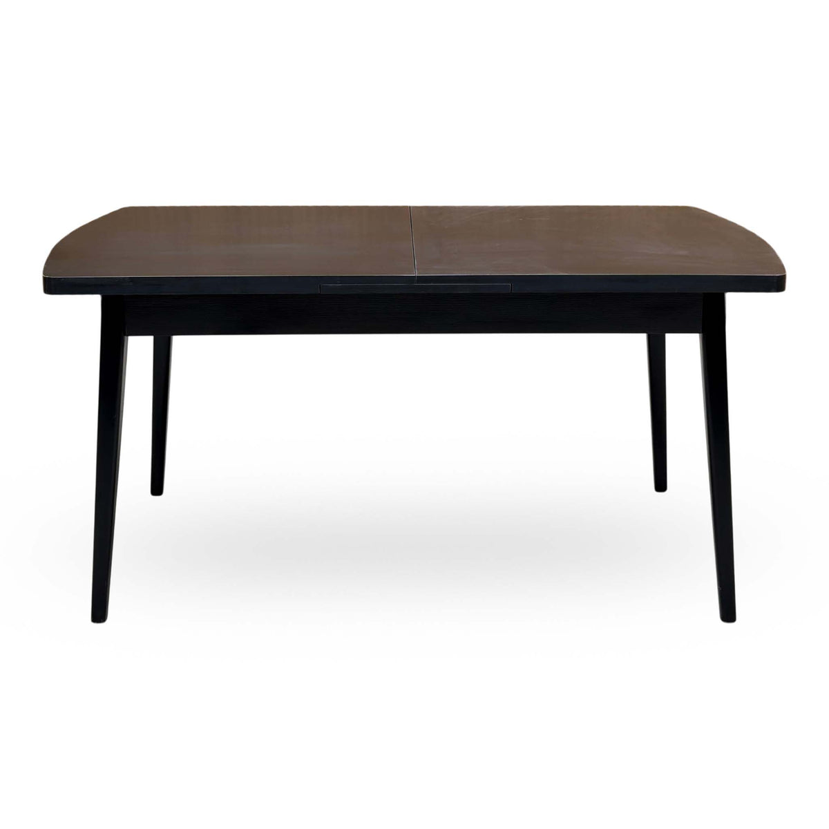 Front view of the Magda black solid oak dining table unextended on tapered legs