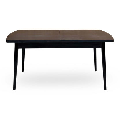 Front view of the Magda black solid oak dining table unextended on tapered legs
