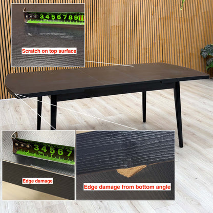Magda black oak table with a scratch on the top and two edge chips marked, tape measure for scale