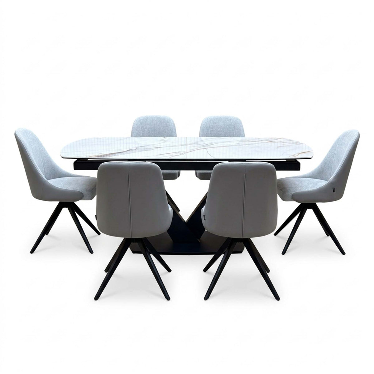 Jose dining set seen from the chair backs, six stone grey swivel chairs around the white marble effect table