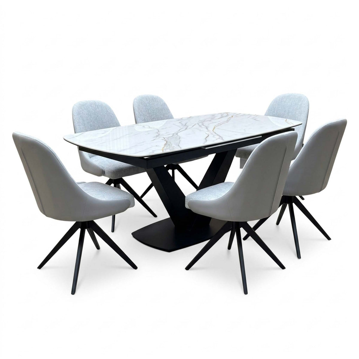 Jose white marble effect ceramic extending dining table with six stone grey faux leather swivel chairs, angled view