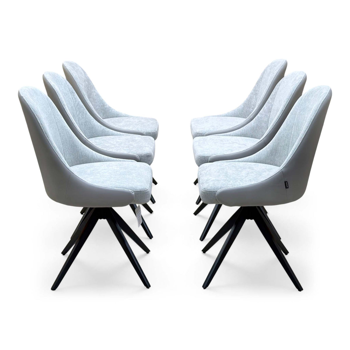 Side view of the six Jose stone grey swivel dining chairs from the set, arranged in two facing rows