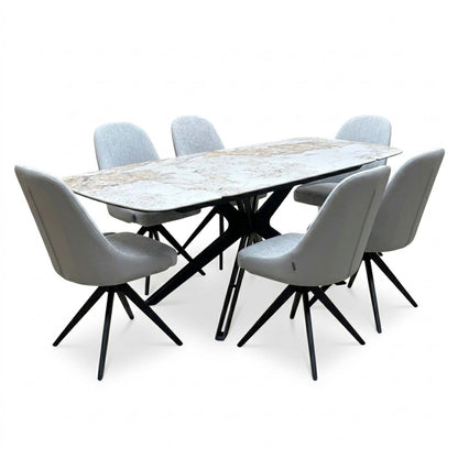 Jose Calcatta marble dining table set with the leaves extended, angled view from the left with six grey swivel chairs
