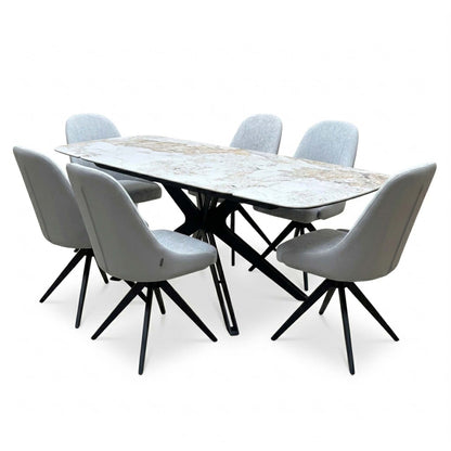 Jose Calcatta marble dining table set with the leaves extended, angled view from the right with six grey swivel chairs