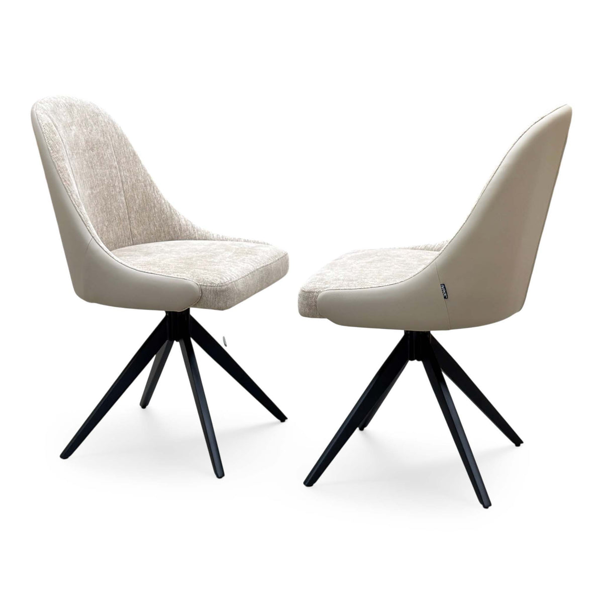 The pair of Jose cream fabric armless swivel dining chairs from the set, angled view