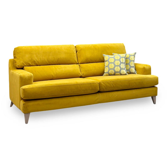 The Lounge Co. Romilly golden spice yellow velvet 4 seater sofa, angled view with tapered wooden legs