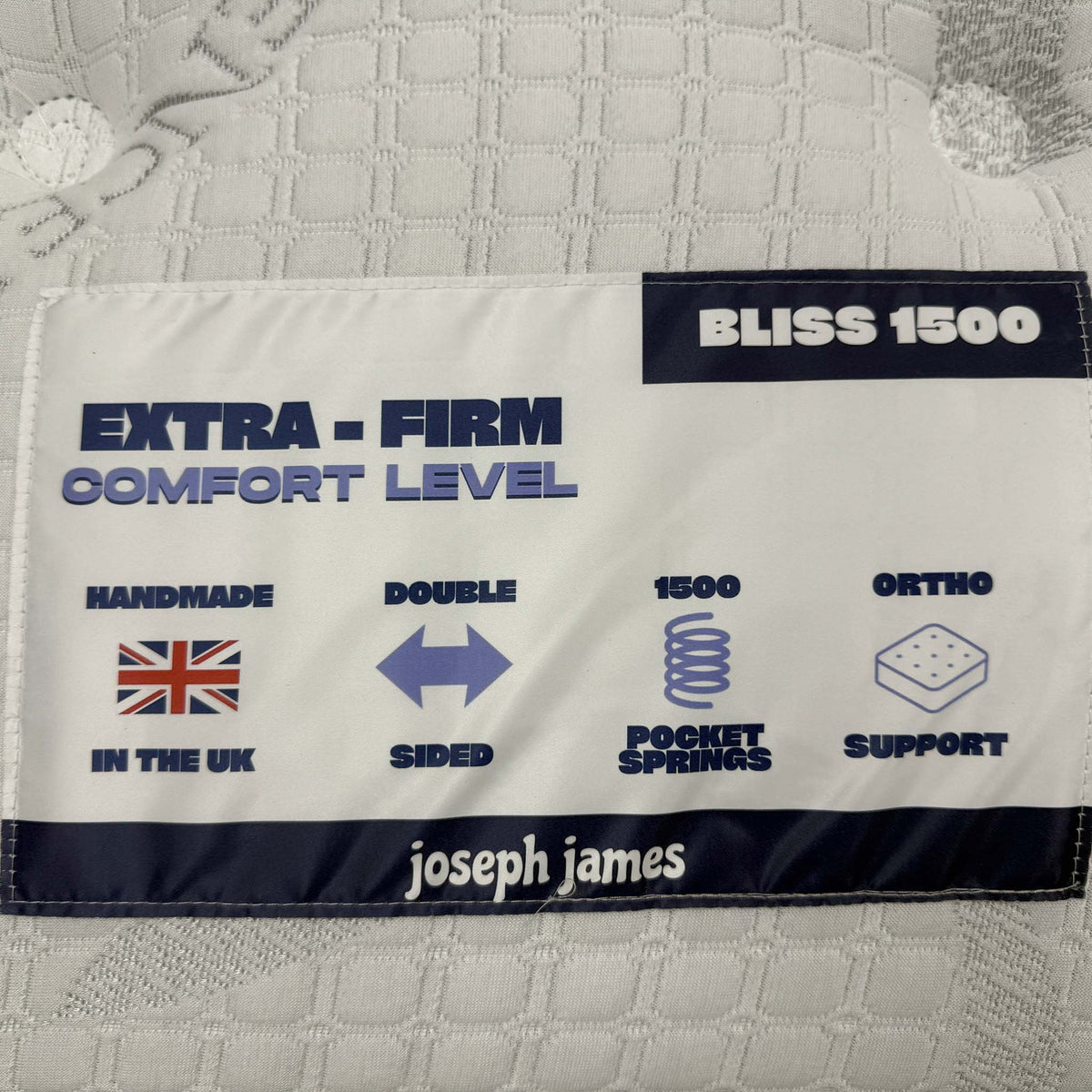 Close-up of the Bliss 1500 mattress label showing extra-firm comfort level, double sided and ortho support