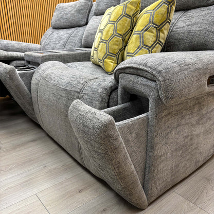 Low angle of the Hollywood dove grey fabric sofa with the right seat reclined, showing the padded arm and side buttons