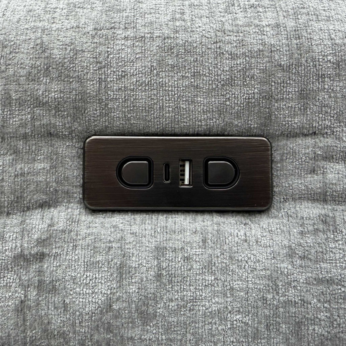 Close-up of the power recline buttons and USB ports on the Darren light grey fabric sofa