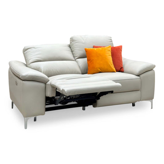 Pavilion soft grey leather 2 seater power recliner sofa, angled with the left seat reclined and orange cushions
