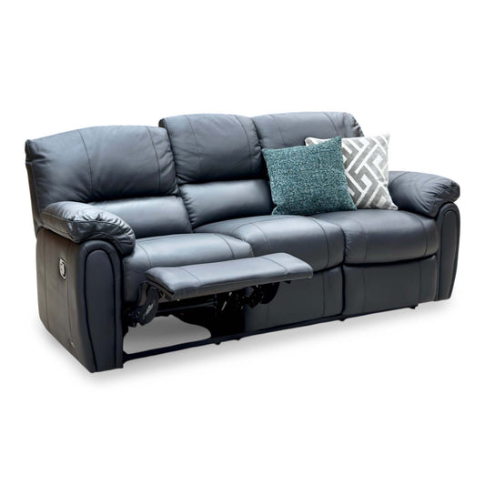 Leighton black faux leather 3 seater recliner sofa, angled view with the left seat reclined and two scatter cushions
