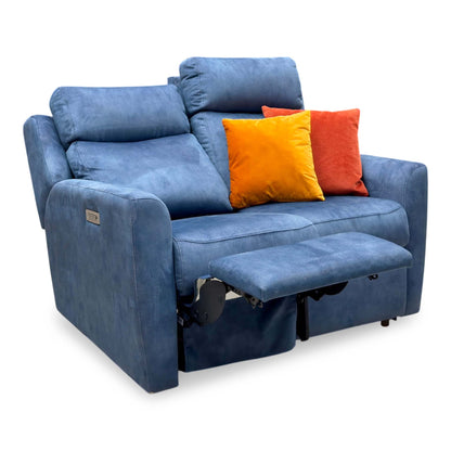 G Plan Wren indigo velvet 2 seater power recliner sofa, angled view with one footrest raised and orange cushions