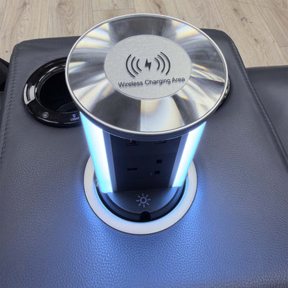 Close-up of the Jude console pop-up charging tower with wireless charging pad, plug socket and LED lighting