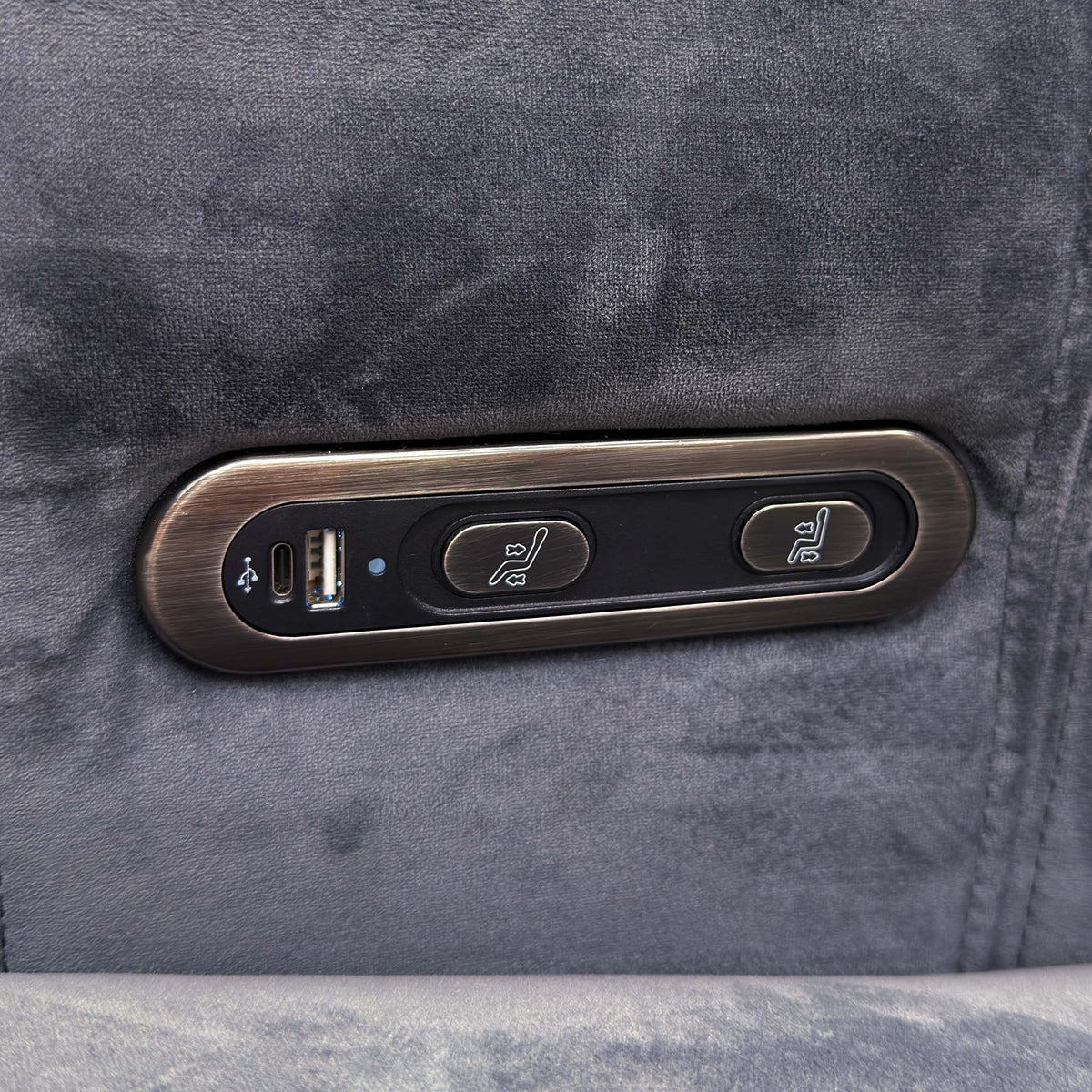 Close-up of the power recline buttons and USB port on the arm of the Elphaba granite grey velvet sofa