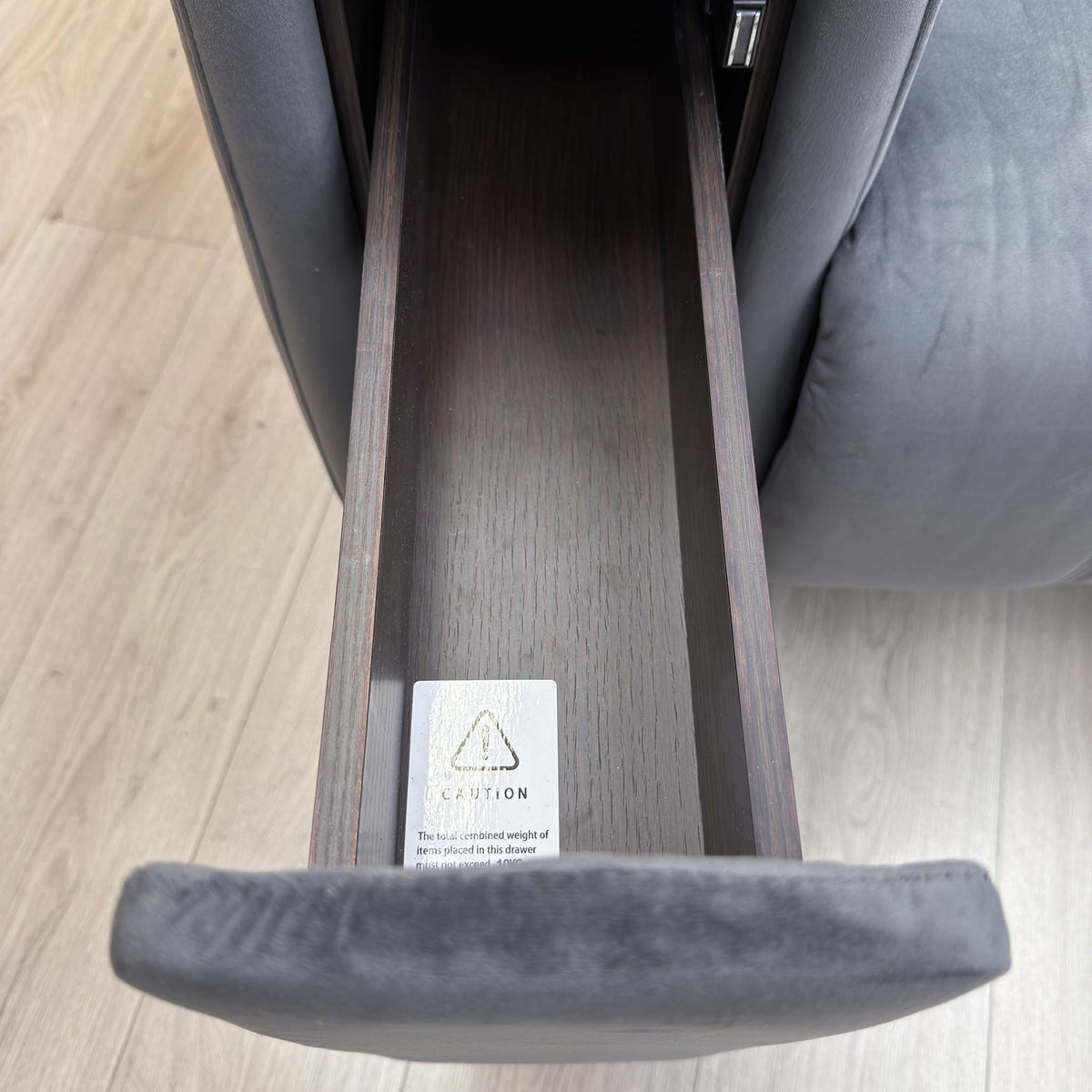 Open storage arm on the Elphaba granite grey velvet sofa seen from above, showing the lined compartment