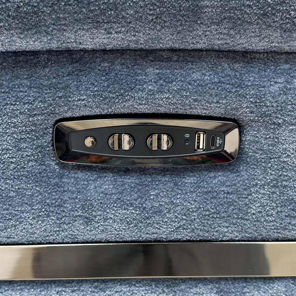 Close-up of the power recline and headrest control panel with USB port on the arm of the Eclipse sofa