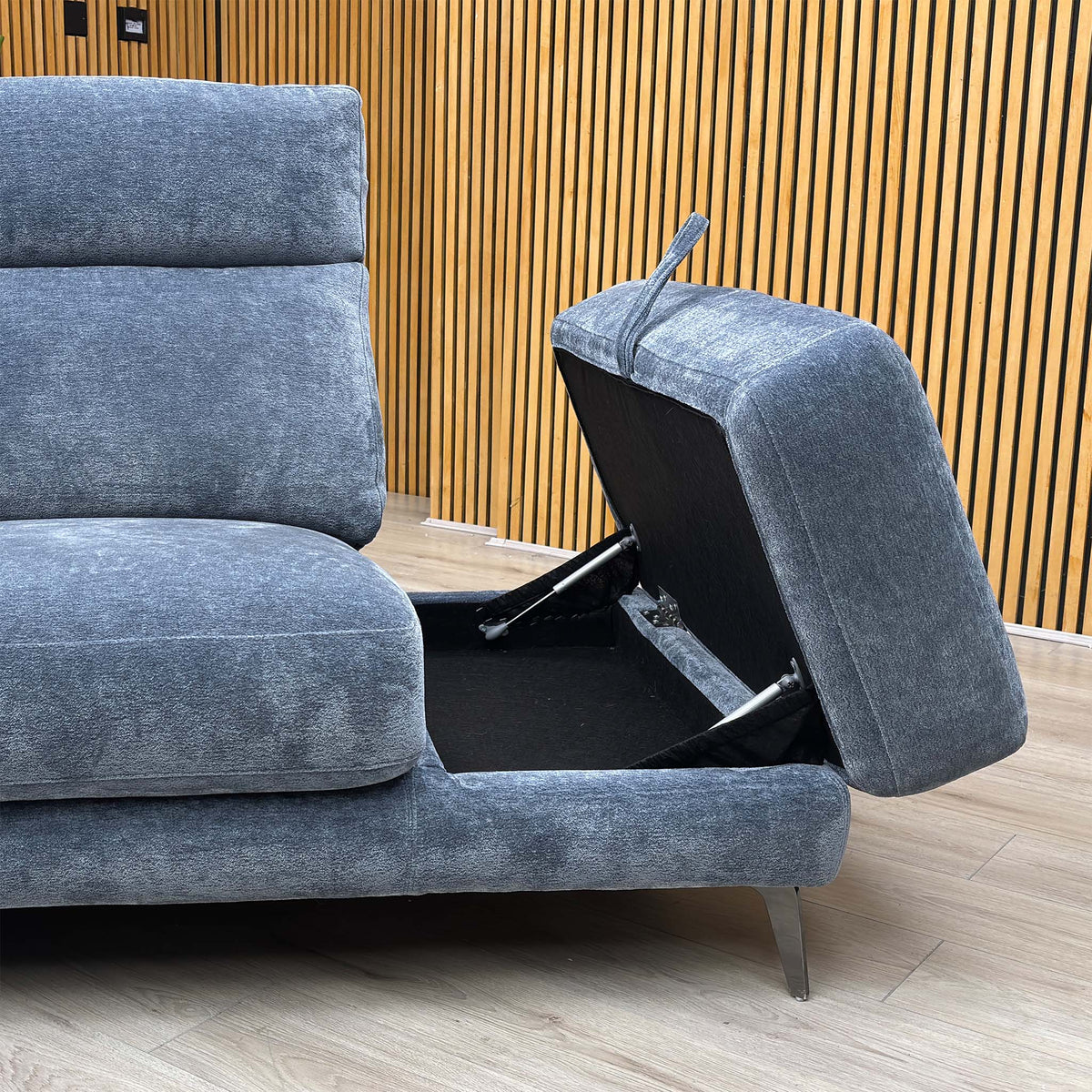 Close-up of the Eclipse silverish blue fabric sofa chaise end with the storage lid lifted open