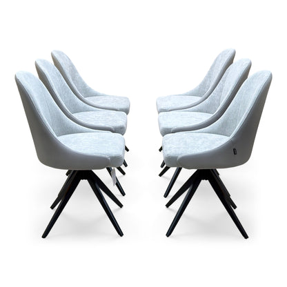 Side view of the six Jose stone grey faux leather swivel dining chairs in two facing rows of three