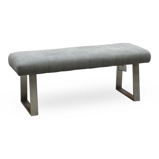 Grigio grey fabric low dining bench with a channel-stitched seat on brushed metal sled legs, angled view