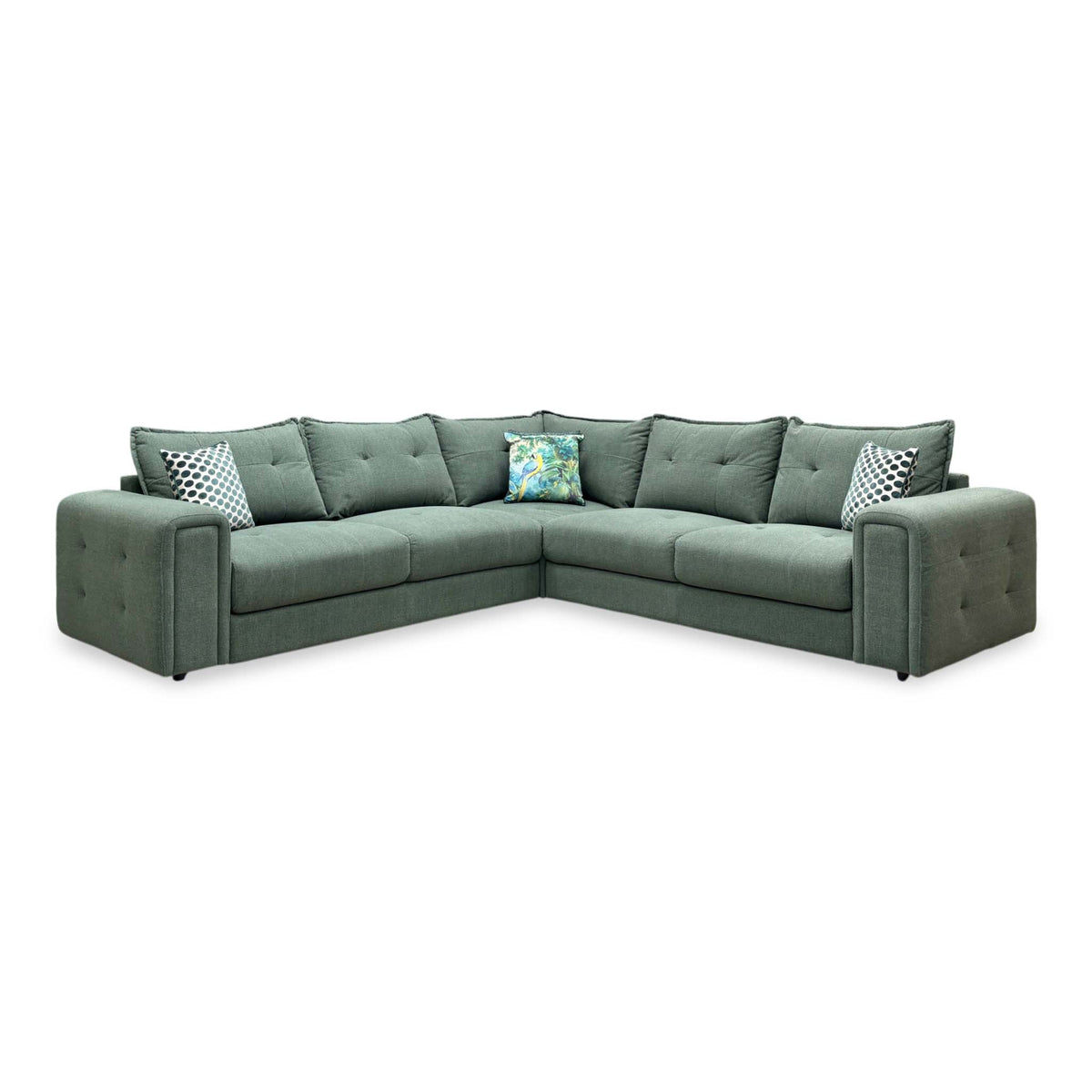 Front view of the Goliath moss green fabric large corner sofa with button detail arms and patterned scatter cushions