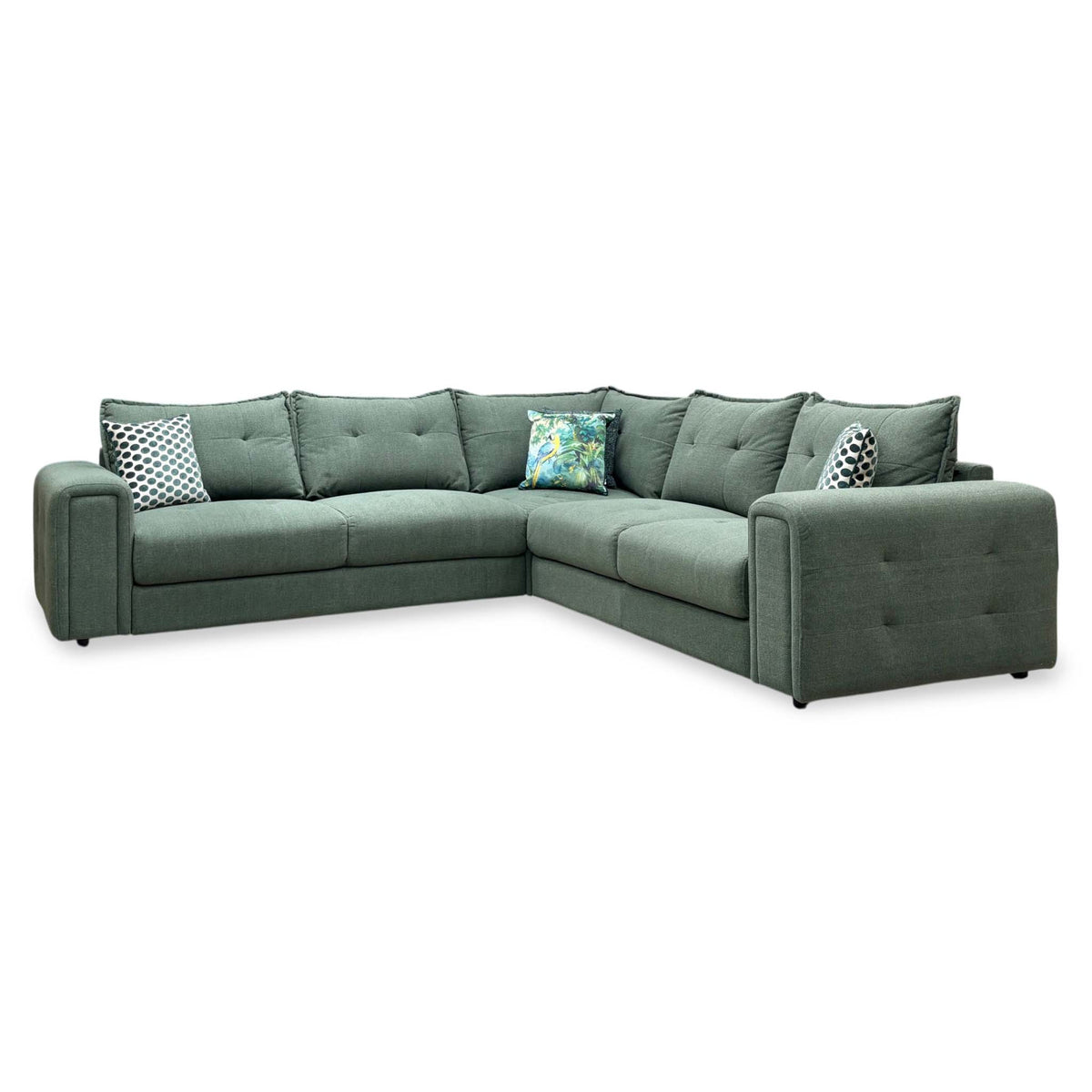 Goliath moss green fabric large corner sofa, angled view from the right with the scatter cushions in place