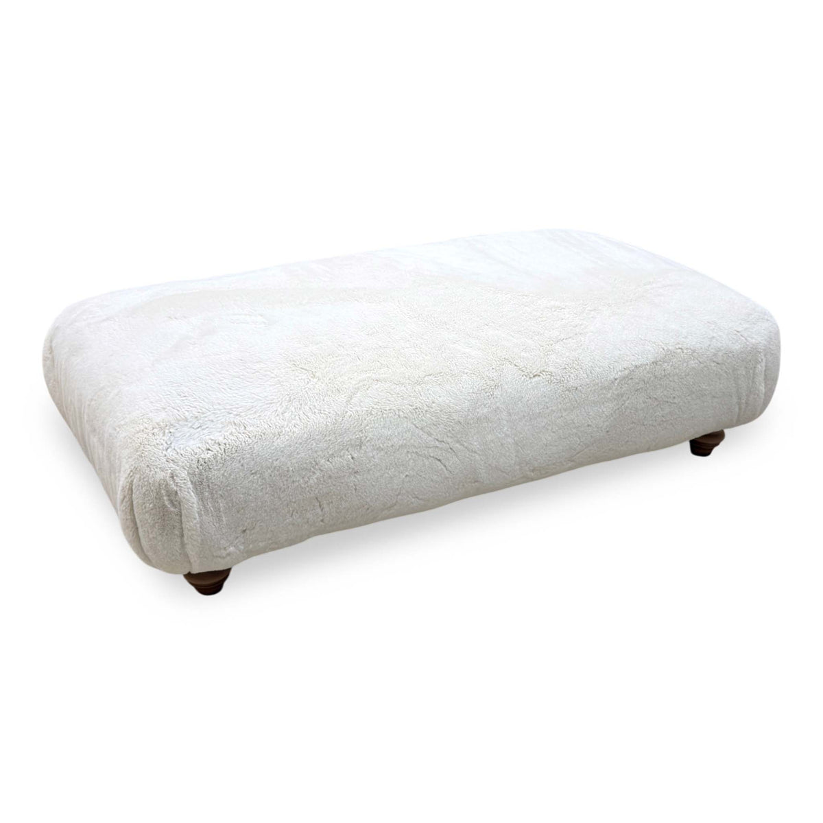 Blenheim Darwin ivory faux fur large footstool on dark wooden bun feet, angled from the right