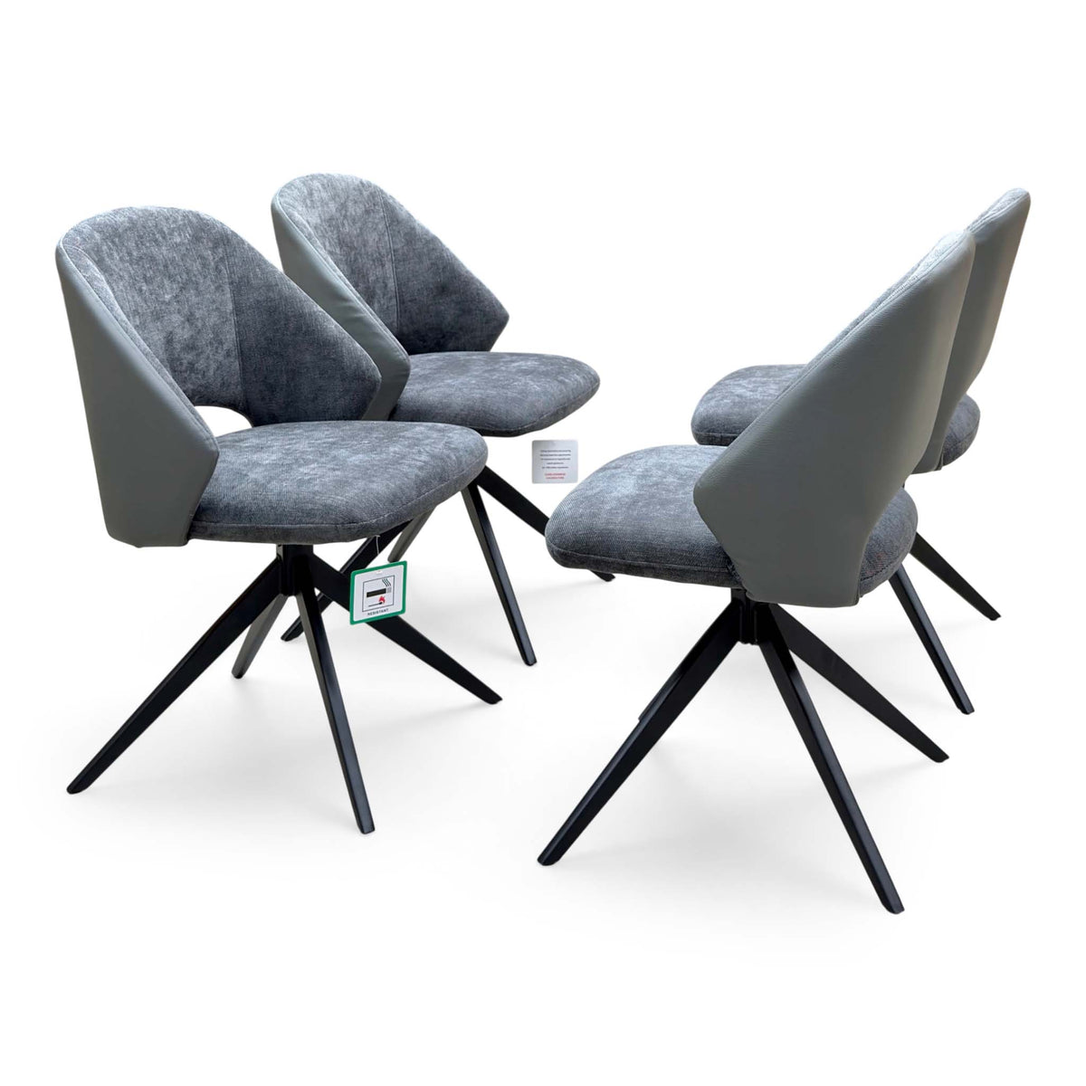 Raul anthracite grey faux leather swivel dining arm chairs, set of four, angled view from the left
