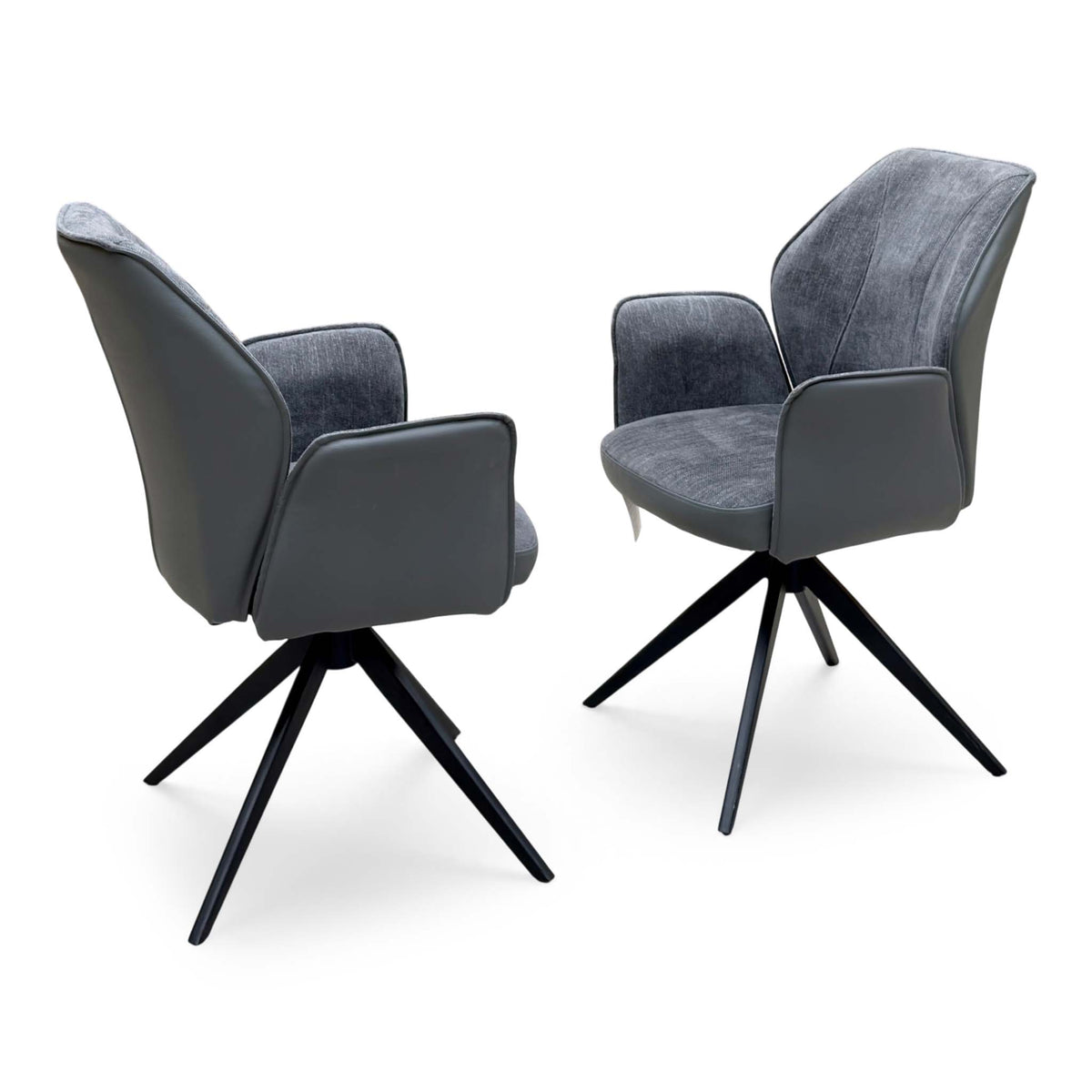 Julio anthracite grey faux leather pair of swivel dining chairs on black star bases, one shown from behind