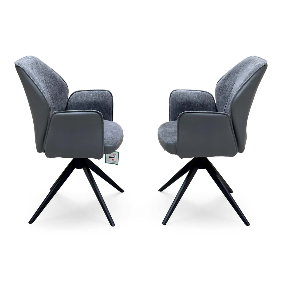 Side view of the Julio anthracite grey faux leather swivel dining chairs facing each other