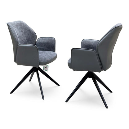 Julio anthracite grey faux leather pair of swivel dining chairs with padded arms, angled front view