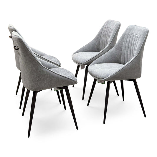 Crete light grey fabric set of 4 dining chairs with fluted backs and black metal legs, angled from behind
