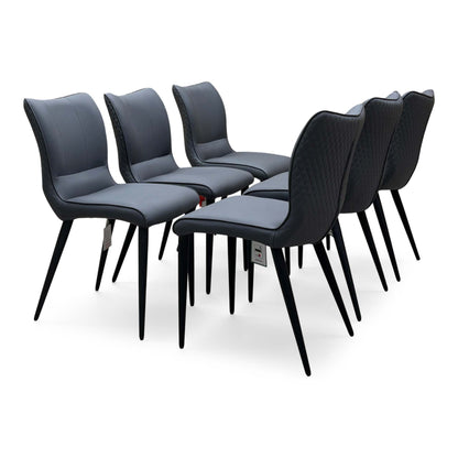 Clio grey faux leather dining chairs, set of six, angled view from the left showing the quilted backs