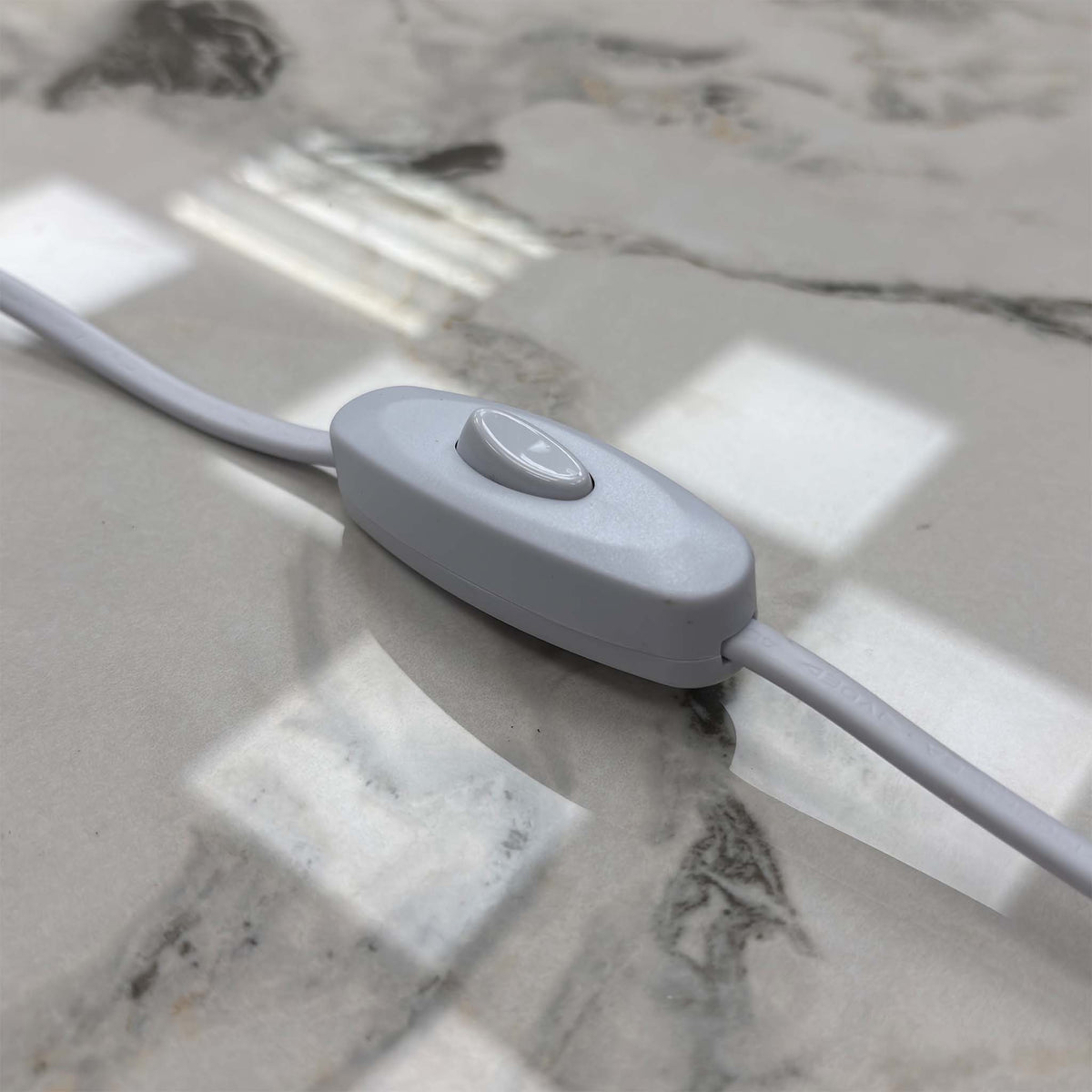 Close-up of the inline LED light switch on the cable of the Avorio ceramic top small sideboard