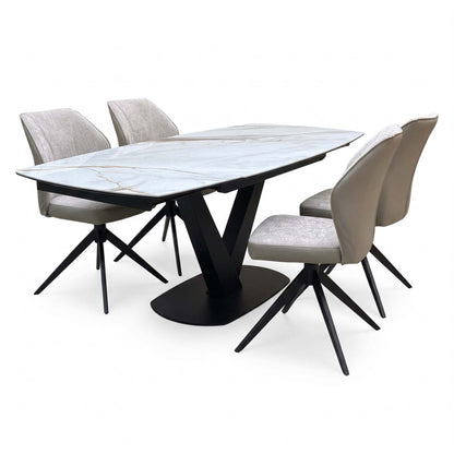 Julio gold-veined marble ceramic dining table and four cream swivel chairs, angled view from the right-hand end
